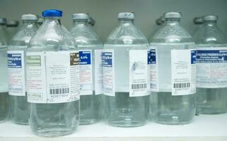 bottles of water are lined up on a shelf photo