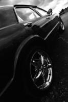 black and white photograph of a car parked on the street photo