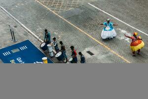 High perspective view of people dressed in traditional Bahia clothes and playing drums to welcome cruise ship passengers disembarking the MSC Seaview in Salvador photo