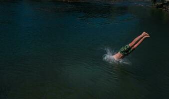 a man in a swimsuit is jumping into the water photo