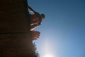 a person standing on a wooden platform with their feet in the air photo