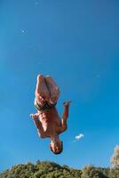 a man in a swimsuit is jumping into the water photo