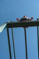 a man is jumping off of a bar photo