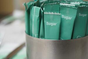 white sugar in a paper packet on table photo