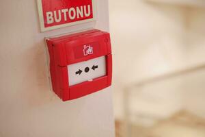 Red fire alarm button on wall , photo