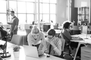 a black and white photo of people working in an office