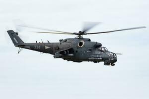 Hungarian Mil Mi-24 military attack helicopter at air base. Air force flight operation. Aviation and Air defense. Military industry. Fly and flying. photo