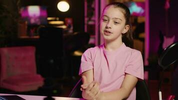 charmant jung Mädchen Schießen Video zum Sozial Medien Plattform im Leben Zimmer, reden Über ihr Tag. Kind unterhaltsam Anhänger, tun Inhalt Schaffung im Neon- zündete Wohnung mit Smartphone auf Stativ