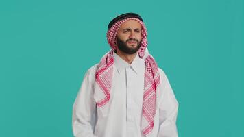 Arab person dressed in traditional islamic clothes making applause sign, congratulating and looking at camera with confident expression. Muslim man showing support and applauding in studio. video