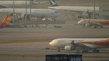 HONG KONG NOVEMBER 07, 2019 Airbus A330 223, B LNI of Hong Kong Airlines on the taxiway at Hong Kong airport. Airplane in sunlight at sunset or dawn video