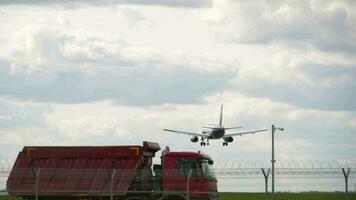 Landing airplane flies over a high speed highway with cars in the city. Travel concept by air or ground. video