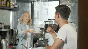 bonito jovem homem sorridente para a Câmera enquanto desfrutando dele café às a cafeteria video