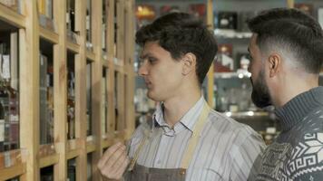 Male wine maker helping his customer while working at his wine store video