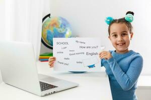 Inglés distancia aprendizaje para niños. educación en el hogar y distancia aprendizaje para niños. niña estudiante estudiar en línea con vídeo llamada maestro. foto