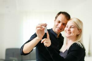 Young smiling couple holding keys of their new house photo