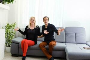 Happy young couple is hugging and smiling while sitting on the couch at the psychotherapist. photo