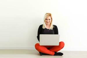 Woman working on a laptop isolated over a white background photo