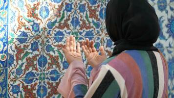 Muslim young woman in hijab is praying in mosque. video