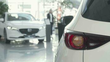 Female customer choosing automobile to buy at dealership salon video