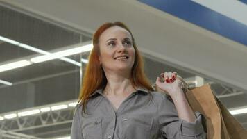 Attractive woman looking around in the mall while shopping video