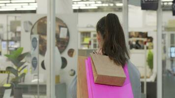 Young woman smiling to the camera carrying shopping bags video