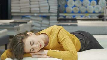 Stunning woman smiling to the camera while lying on orthopedic mattress video