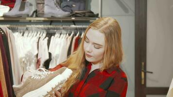 feliz jovem mulher sorridente para a Câmera enquanto compras para calçados video