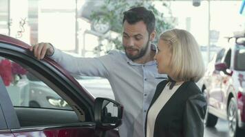 Happy couple choosing new automobile at the dealership video