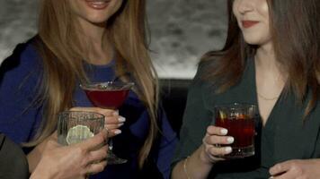 beskurna skott av tre kvinna vänner klirr cocktail glasögon på de bar video