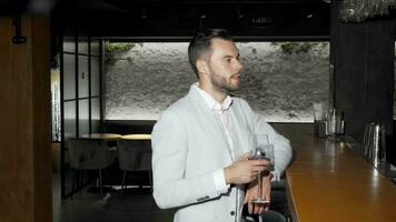 Handsome elegant young man enjoying drinking wine at the bar video