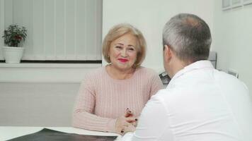 Happy healthy senior woman receiving good news on her medical appointment video