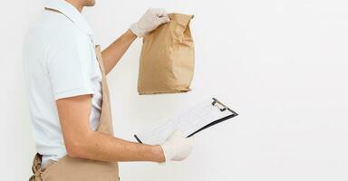 Holding take-out food paper bag. Light grey background, place to insert your text. Delivery man. photo
