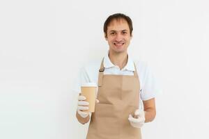 Holding take-out paper coffee cup. Light grey background, place to insert your text. Delivery man. photo