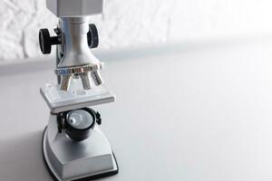 microscope stands on a table on a white background photo