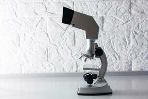 microscopio soportes en un mesa en un blanco antecedentes foto