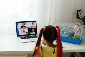 Educate at home. Child girl make homework with pet hamster. Funny ginger hamster sitting on table where kid is writing. Back to school. photo