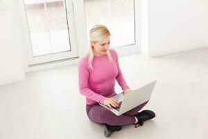 feliz joven hermosa mujer usando laptop, en el interior foto