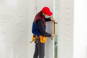handsome young man installing a door in a new house construction site photo