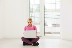 feliz joven hermosa mujer usando laptop, en el interior foto