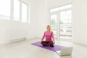 Woman sitting and performing yoga in office photo