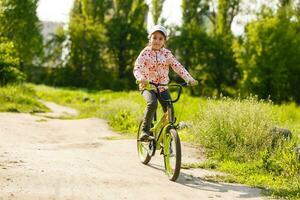 contento pequeño niña con su bicicleta foto