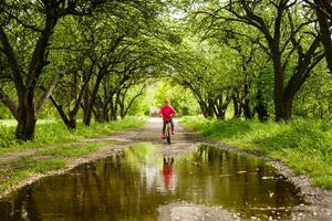 little girl riding bike in water puddle photo