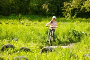 Portrait of a little girl on a bicycle in summer park outdoors photo