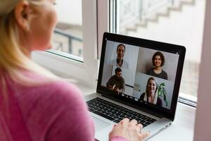 Woman Working From Home Having Group Videoconference On Laptop photo