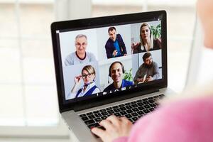 Woman Working From Home Having Group Videoconference On Laptop photo