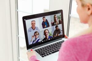 Woman Working From Home Having Group Videoconference On Laptop photo