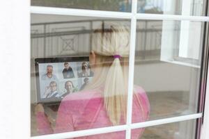 Woman video conferencing with tutor on laptop at home. Distance education concept. photo