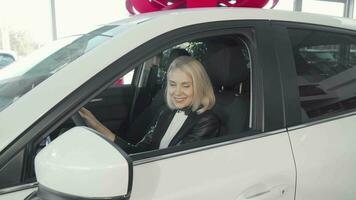 Happy woman showing thumbs up sitting in her new car video