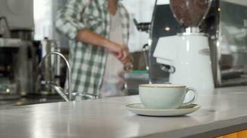 Kaffee Tasse auf das Zähler Barista Arbeiten beim das Kaffee Geschäft auf Hintergrund video