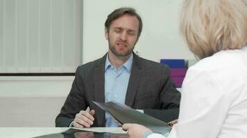 Mature man with joint pain talking to his doctor after xray scanning video